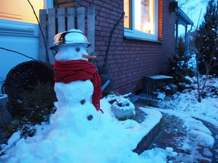 zeigt einen Schneemann im Garten des Ferienhauses