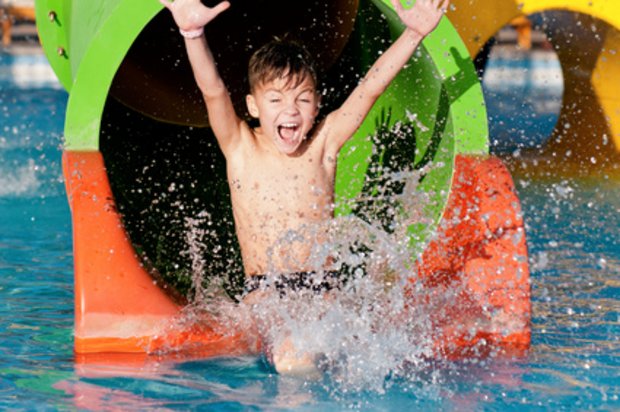 Kind auf einer Wasserrutsche im Spaßbad