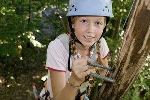 zeigt ein Mädchen beim Klettern im Kletterpark Dankern